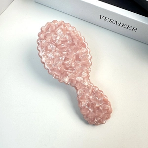 Chic pink acetate hairbrush with shell texture and scalloped edges for gentle scalp massage