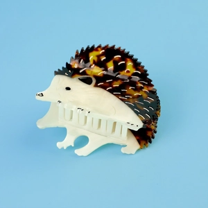 Creative hedgehog-shaped hair claw clip with tortoise shell pattern on blue background