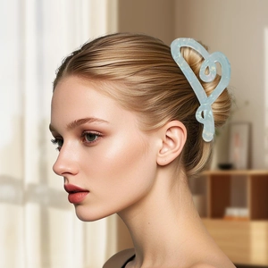 Pince à cheveux cœur en acétate bleu clair montrée sur un mannequin pour un look élégant