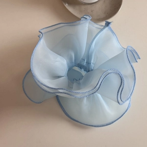 Detailed view of light blue puff mesh scrunchie with layered pleats and ruffled texture