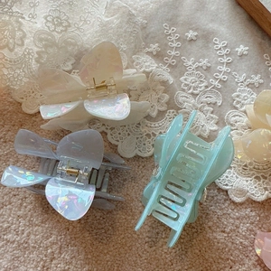 Detail of floral hair claws in multiple pearlescent colors with shimmering finish