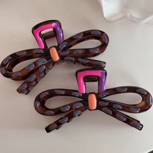 Elegant set of two bow-shaped hair claws with tortoise shell texture and colorful dots