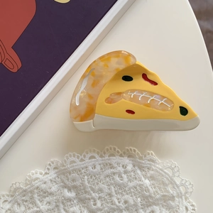 Macro shot of creative acetate pizza slice hair claw with realistic food details