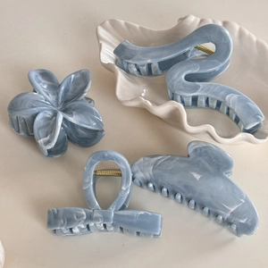 Set of four blue marble texture hair claws in floral and wave shapes for women