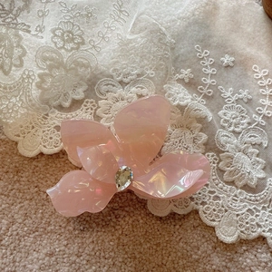 Detailed view of pink flower hair claw with iridescent finish and teardrop diamond
