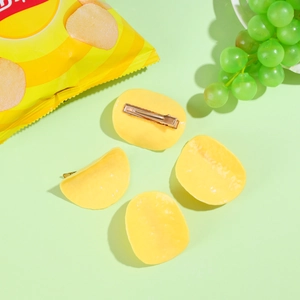 Detailed view of four realistic yellow potato chip hair clips with metal duckbill fasteners
