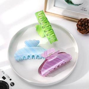 Three gradient acetate hair claws in pastel green, blue, and purple with striped texture
