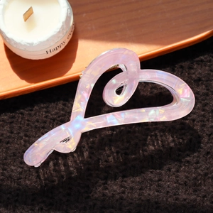 Vue détaillée d'une pince à cheveux en forme de cœur avec une finition rose violette nacrée
