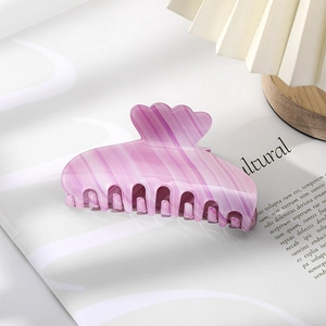 Detailed macro view of purple marble pattern hair claw clip on magazine background