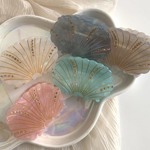 Pinces à cheveux en forme de coquillage avec strass en cinq couleurs sur plateau perlé