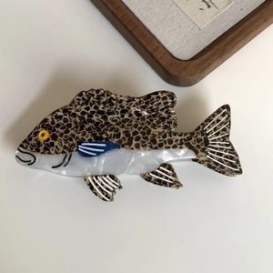Detailed close-up of a large acetate shark clip with creative fish design and blue fins