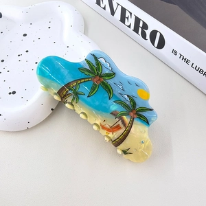 Macro detail of tropical beach theme hair claw clip with hand-painted palm tree design
