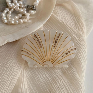 Détail de la pince à cheveux coquillage avec strass sur satin blanc et perles