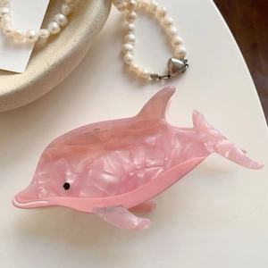 Vue détaillée de la pince à cheveux dauphin rose en acétate avec une texture marbrée élégante