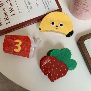 Cute fruit-shaped hair claws featuring banana and strawberry designs in glossy acetate