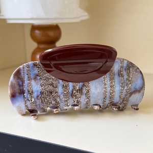 Detailed macro view of the large tortoiseshell hair claw clip with a glossy marble texture