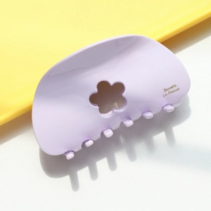 Détail de la pince à cheveux lilas en acétate avec motif fleur et texte imprimé