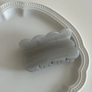 Detailed view of grey wavy edge hair claw clip with pearlescent resin finish