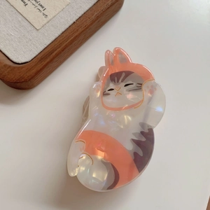 Detailed macro view of an orange-hooded cat claw clip with pearlescent acetate finish