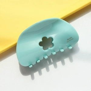 Détail d'une pince à cheveux vert menthe avec fleur découpée et texte Barrette La France