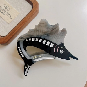 Detail view of a swordfish acetate hair claw clip with black and grey marble texture