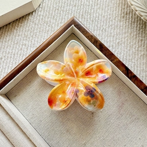 Floral print plumeria hair claw clip with yellow blossoms in clear resin material