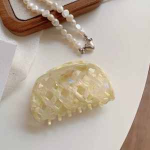 Detailansicht der beigen Haarklammer im Waffel-Design mit schillernder Acetat-Textur