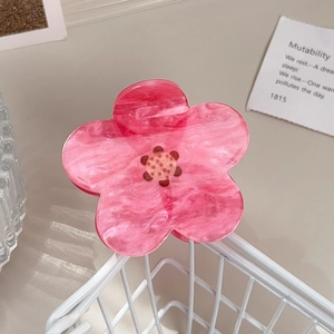 Pink floral acetate hair claw clip with marble texture detail on a metal frame