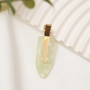 Detailed view of pale green marbled acetate hair clip with premium gold metal finish