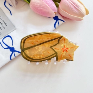 Detailansicht der sternfruchtförmigen Haarklammer aus Acetat mit goldener Glitzerstruktur