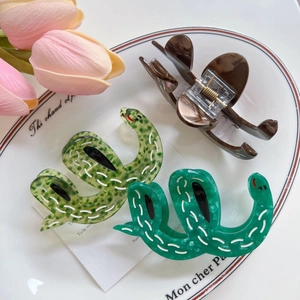 Three-piece acetate hair claw set featuring creative snake designs and brown glossy clips