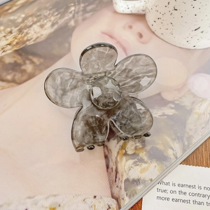 Détail de la pince à cheveux en fleur d'acétate marbré gris sur un fond de style de vie