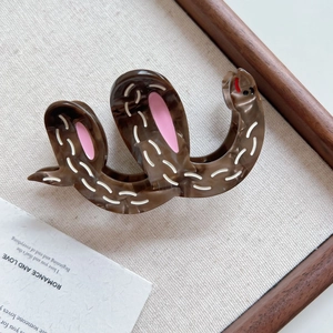 Detailed view of the wavy leopard print acetate hair claw clip on linen backdrop