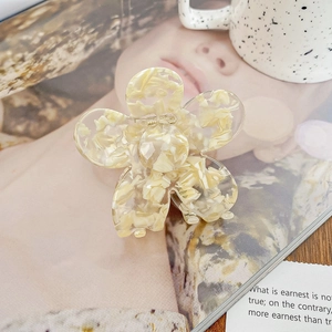Détail d'une pince à cheveux fleur avec texture marbrée de nacre crème et style de vie