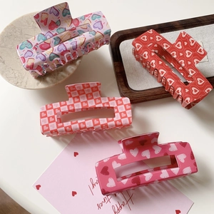 Acrylic rectangular hair claws with colorful heart patterns and Valentine's Day motifs