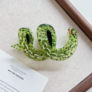 Detailed macro of a green translucent acetate hair claw clip in a unique snake shape
