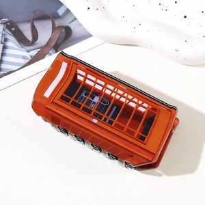 Detail shot of a red vintage phone booth hair claw clip on a stylish decorative tray