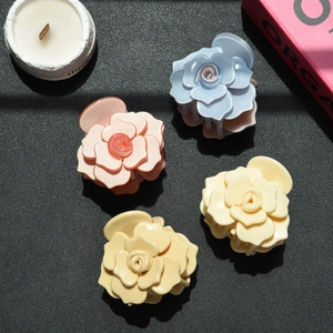 Détail de quatre pinces à cheveux rose en acétate en bleu, rose, crème et jaune