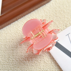 Gros plan sur la pince à cheveux rose en forme de rose avec des pétales en acétate