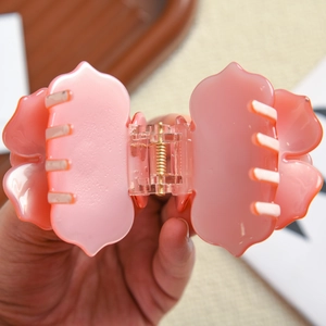 Gros plan sur la pince à cheveux rose pâle montrant le mécanisme de ressort en métal