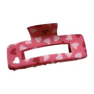 Pink acrylic rectangular hair claw clip with heart pattern on a clean white background
