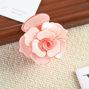 Vue détaillée d'une pince à cheveux rose en acétate avec pétales 3D pour un style élégant