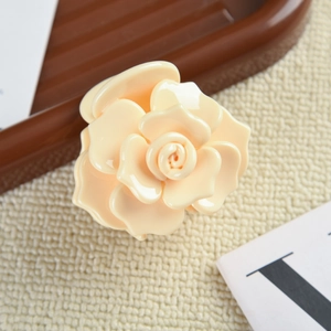 Détail de la pince à cheveux rose en acétate crème avec des pétales 3D élégants