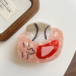 Close-up of baseball glove hair claw clip with pink marble texture and cute face detail
