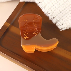 Détail du clip à cheveux en forme de botte de cowboy en acétate marron et orange