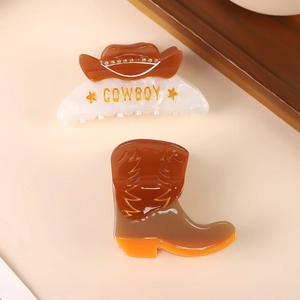Détail de pinces à cheveux en acétate en forme de chapeau et botte de cowboy dorés