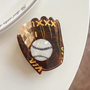 Détail d'une pince à cheveux en forme de gant de baseball en acétate marron poli