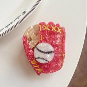 Pince à cheveux en acétate rose en forme de gant de baseball avec détails de balle dorés