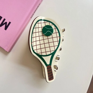 Detailed view of tennis racket claw clip in acetate material with a cute green ball pattern