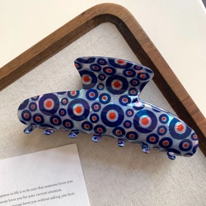 Macro detail of Evil Eye hair claw clip made of blue acetate with circular patterns